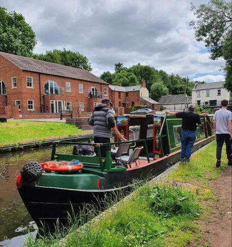 The Trebalisa narrowboat moored at Compton (Wolverhampton) with one person on the deck and two on the towpath