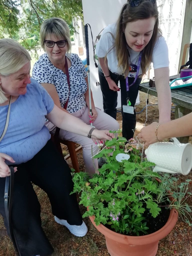 Lisa and Louise being wired up to a geranium by a Sense staff member