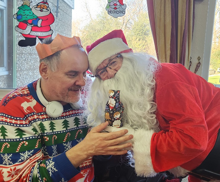 Santa gives a Christmas gift to an SVI member