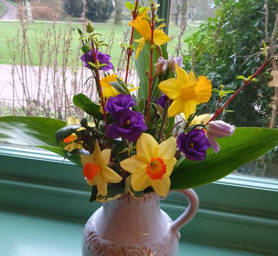 A vase of spring flowers with narcissi and daffodils