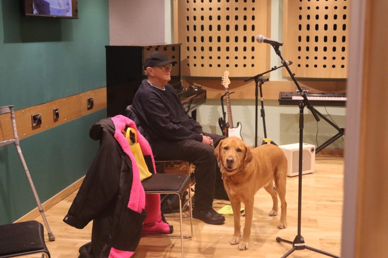 Guide Dog Morse & owner Bill wait for the green light to sing in the Midland Art Centre recording studio