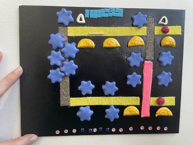 A tactile map of the Beyond Vision route through Warley Woods, made from textured air-dry clay pieces for trees, felt and sandpaper pathways, and a plastic diamante street road.