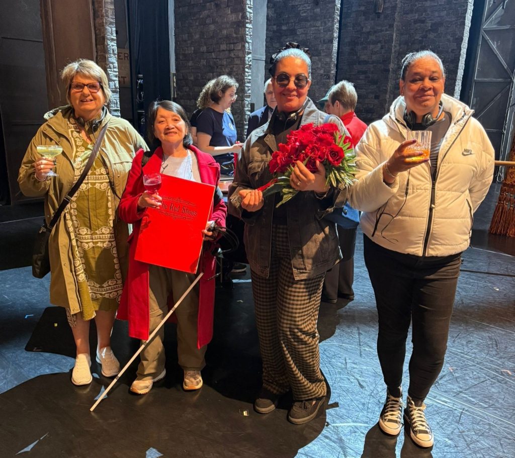 A group of four SVI members backstage with drinks.